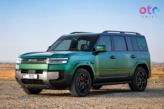 Front three-quarter view of an emerald green BYD Yangwang U8 luxury SUV parked in an arid desert area.