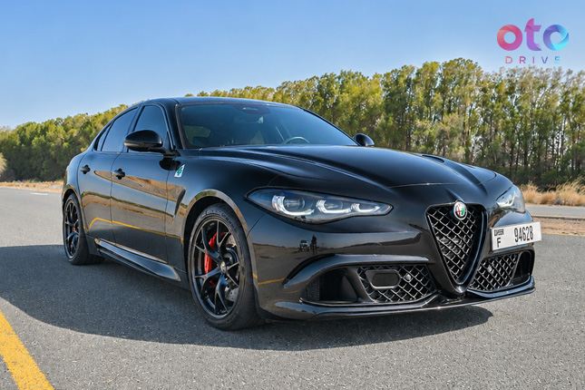 Front three-quarter view of a black Alfa Romeo Giulia Quadrifoglio sports sedan parked on road